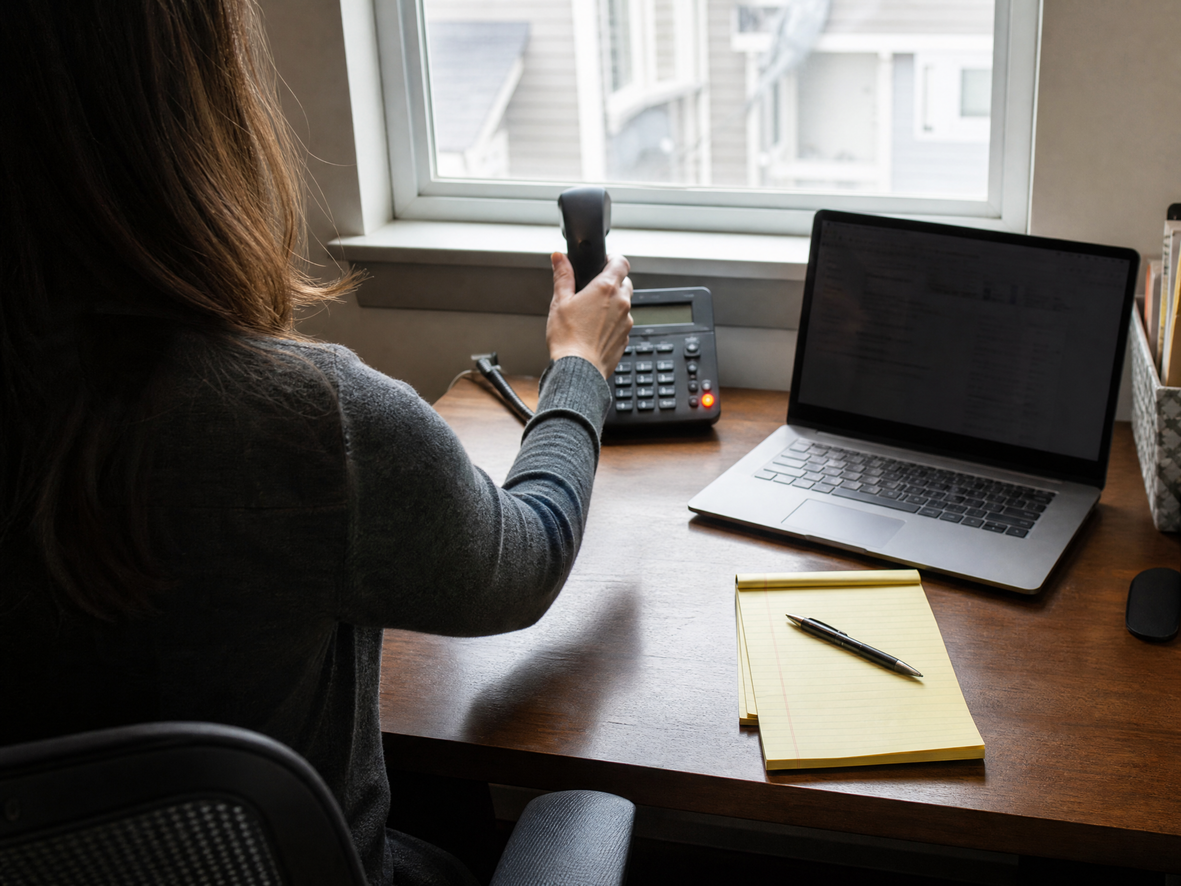 Phone being answered at a small office desk