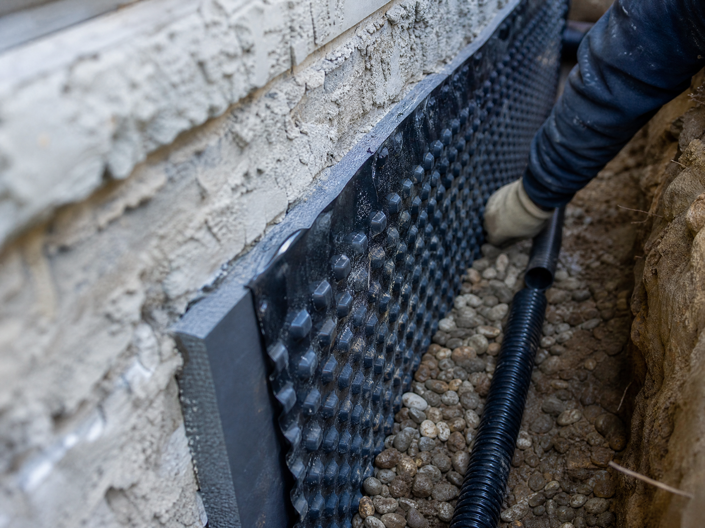 Close-up detail of materials and technique used in basement waterproofing — showing quality