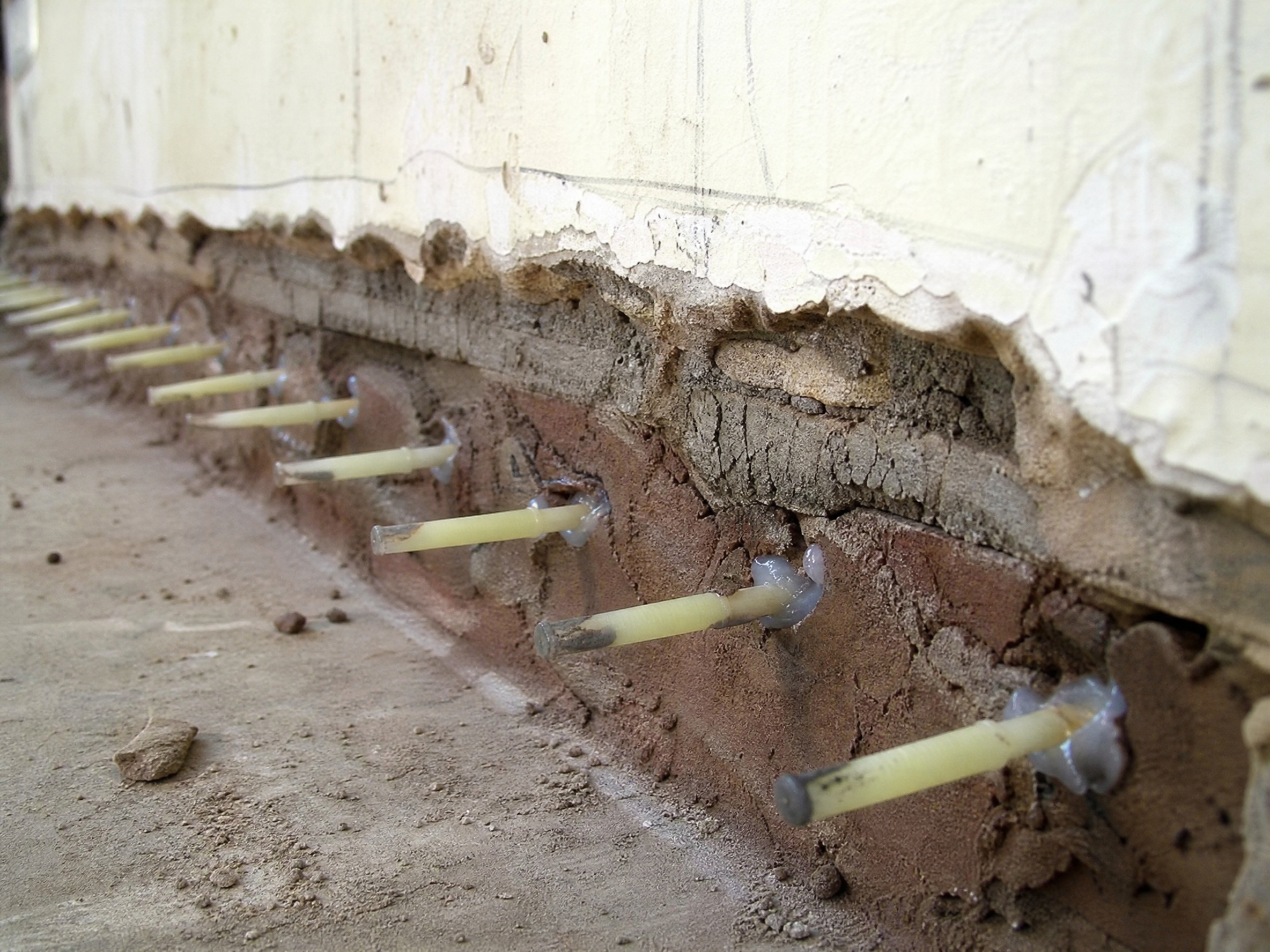 Close-up detail of materials and technique used in rising damp treatment — showing quality